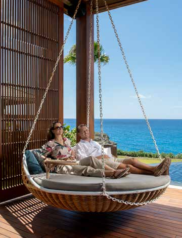 A couple sitting on a swing together by the ocean in the Dominican Republic